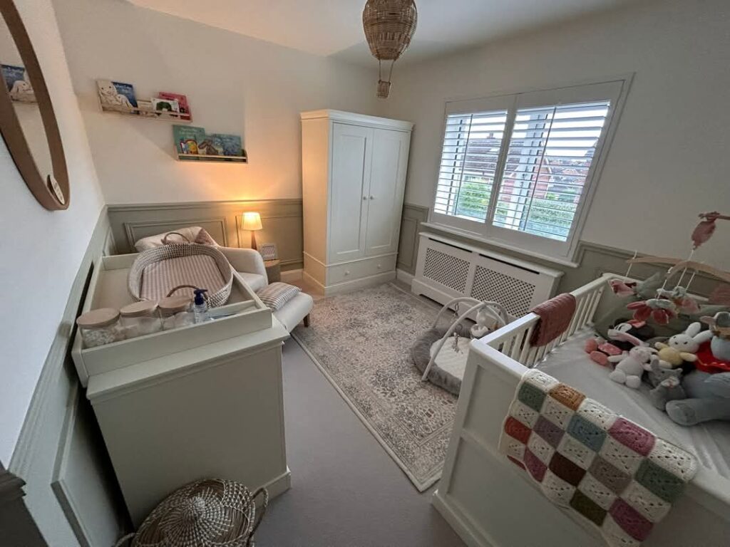 Cozy baby nursery with crib, changing table, and soft lighting in a neutral color palette.