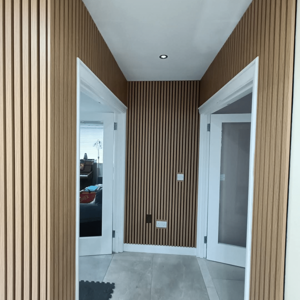 Modern hallway with wooden panel walls, two doors on either side, and a ceiling recessed light.