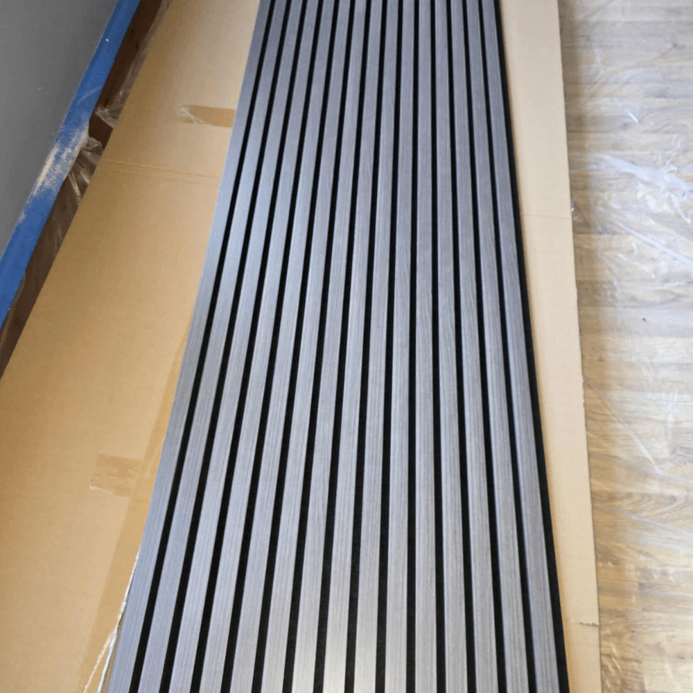 Wooden slat panel leaning against a wall on a hardwood floor.