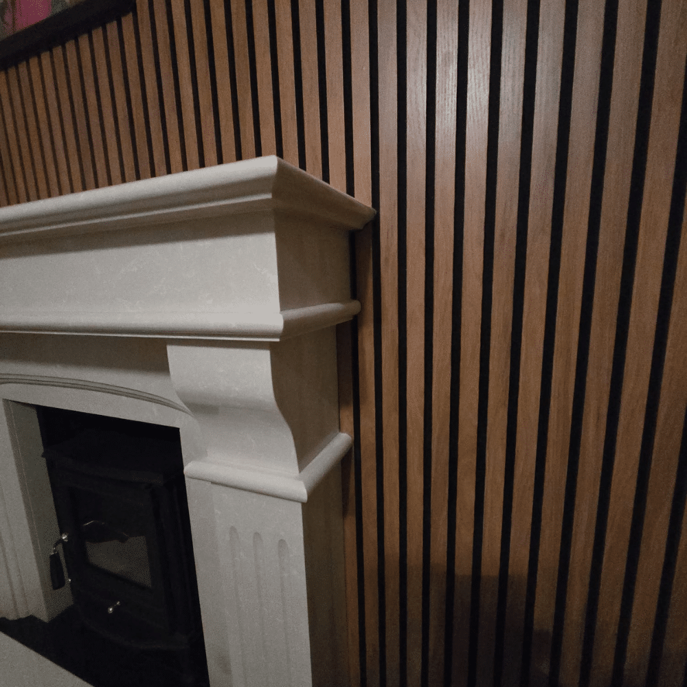 White fireplace adjacent to wood slatted wall.