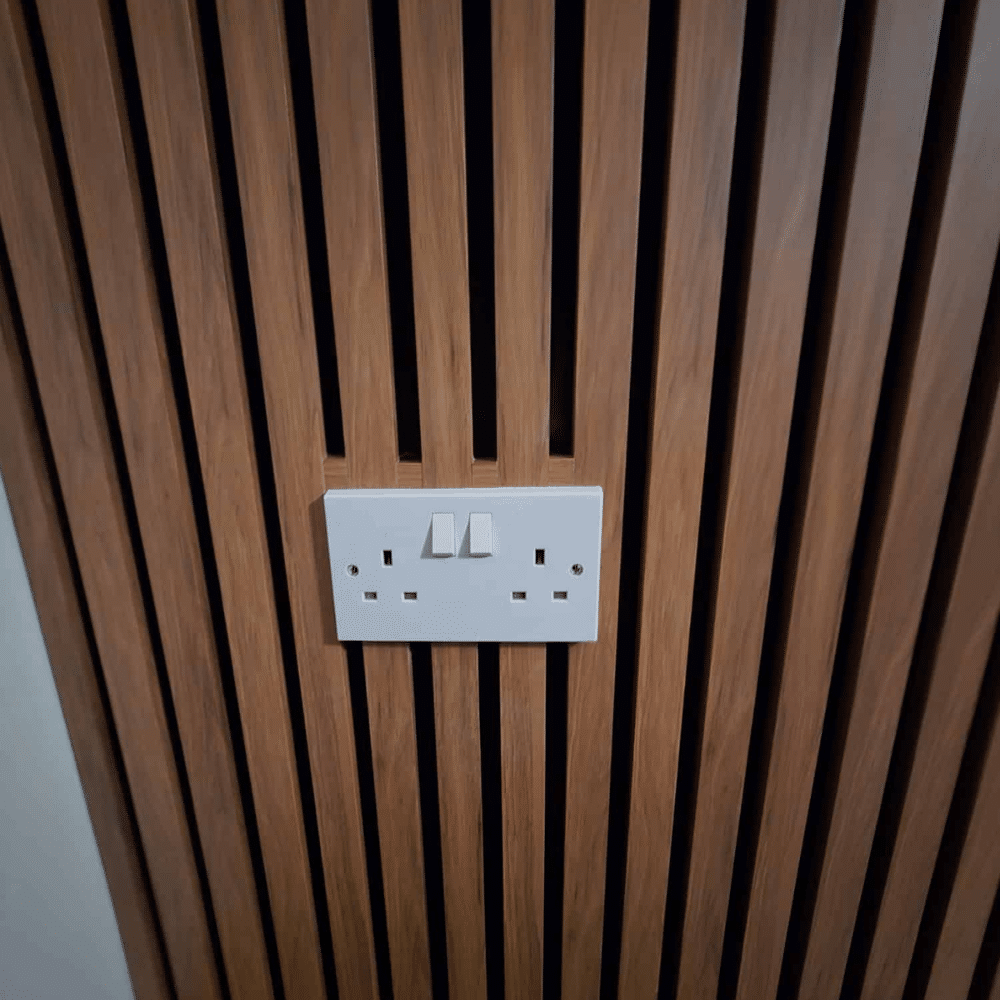 Electrical outlet on a wooden slatted wall.